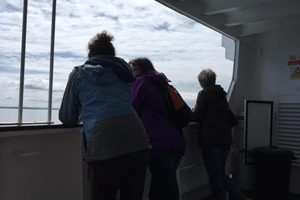 4 people on a boat looking to sea